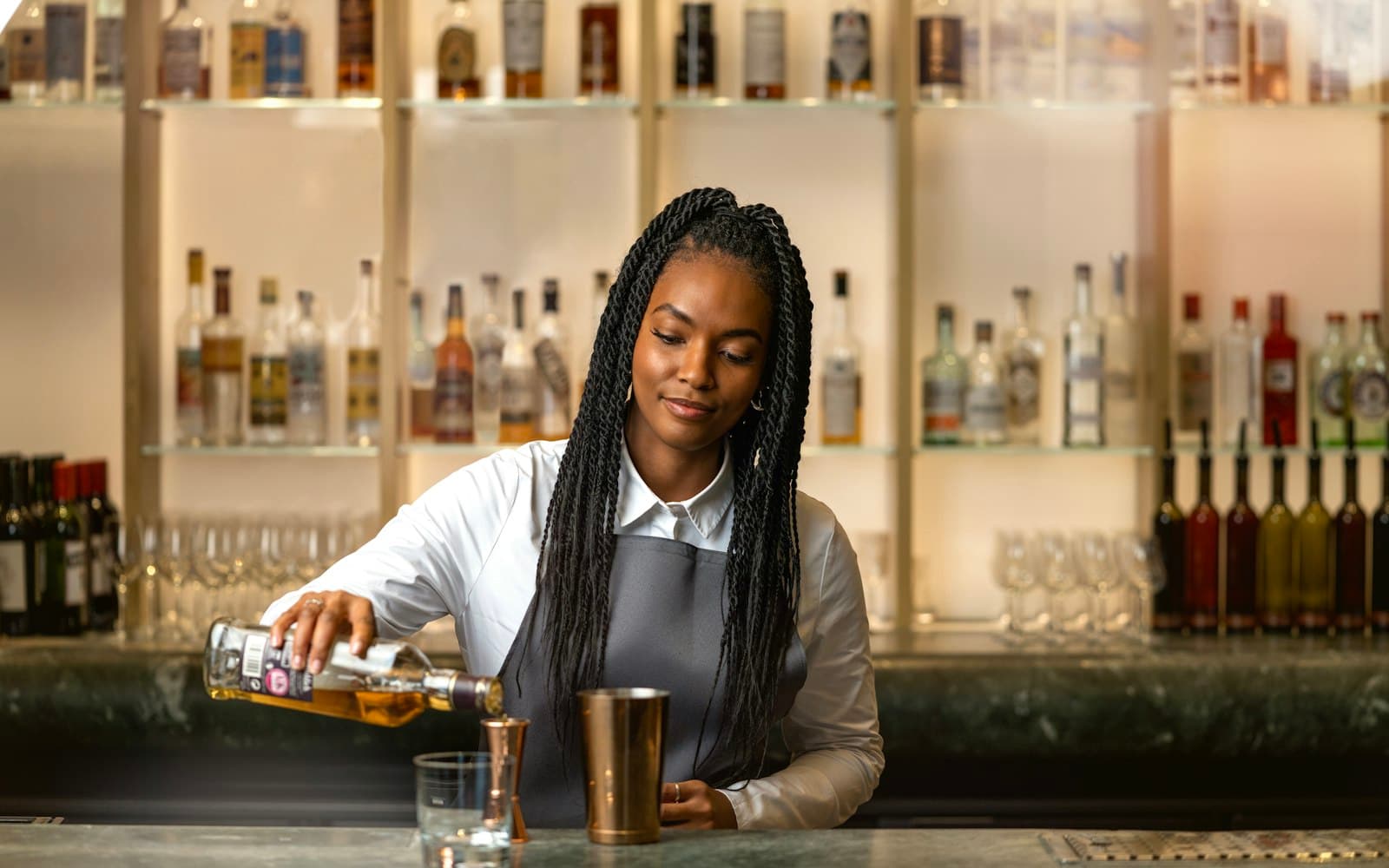 Bartender working behind a bar in daylight